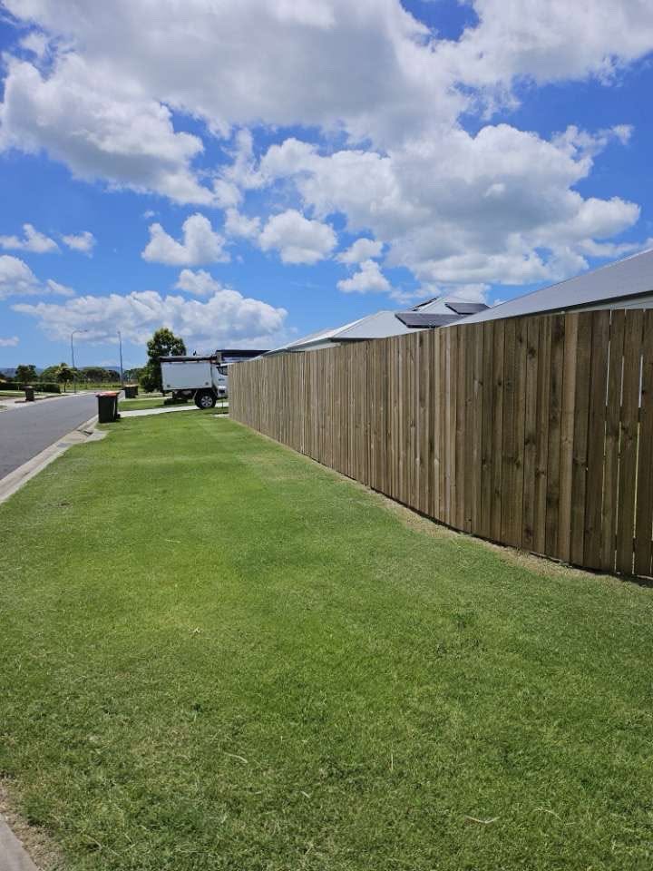 Freshly mowed nature strip alongside a timber fence on a sunny Whitsundays street
