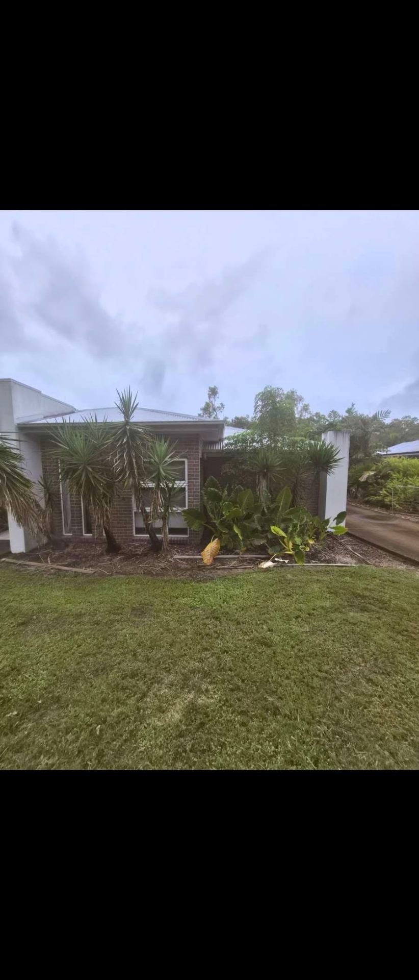 Front yard garden bed prepped and mulched alongside a healthy green lawn